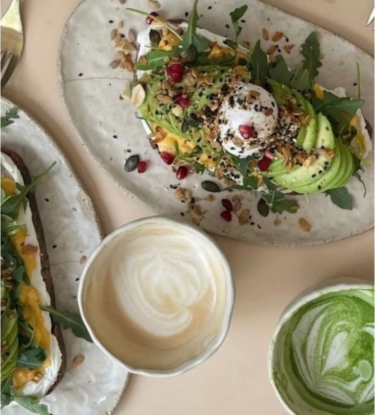 Tostadas de palta, café con leche y matcha sobre una mesa